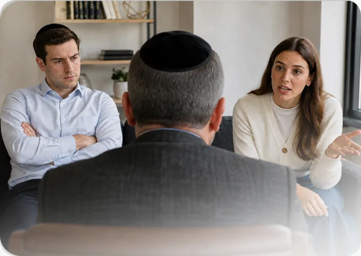 A couple speaking calmly with a professional mediator in a comfortable setting